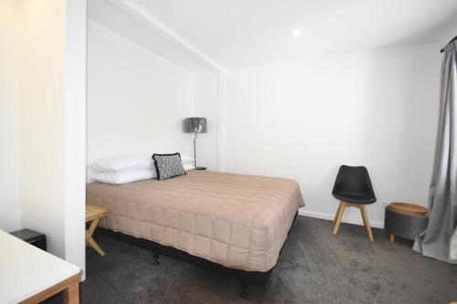 um quarto com uma cama, uma mesa e uma cadeira em Premium Comfortable Lake View 2BR em Taupo