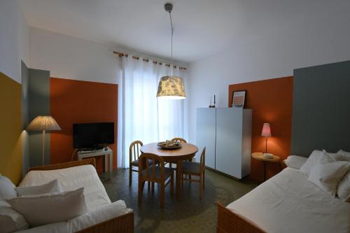 sala de estar con mesa y sofá en Appartamento Doria [5 minuti a piedi dal mare], en Andora