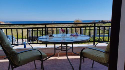 una mesa y sillas en un balcón con vistas al océano en AGNANTIO HOME, en Monemvasia