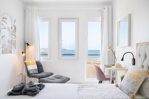een slaapkamer met een bed, een stoel en ramen bij penthouse over the sea in Costa Teguise