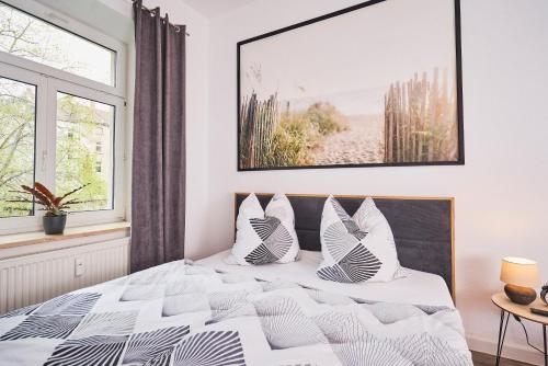 a bedroom with a bed with a picture on the wall at Gemütliche Ferienwohnung für die ganze Familie in Leipzig