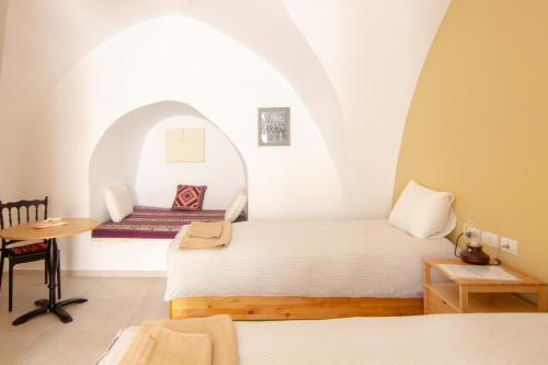 Zimmer mit einem Bett und einem Tisch in der Unterkunft Dar As-Sideh pilgrim house in Bethlehem