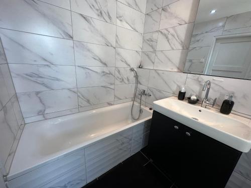 a bathroom with a white tub and a sink at Apartment YuPa in Košice