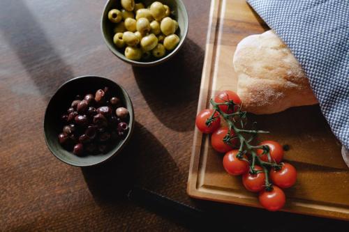 een tafel met twee kommen tomaten en een bord brood bij The Old Sweet Shop, 4 Bedroom House 