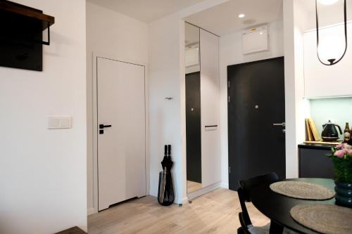 a living room with a table and a door at Nadmorski Loft Rezydencja Niechorze 116 plaża ogród in Niechorze