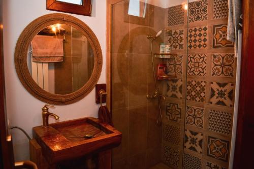 a bathroom with a sink and a mirror and a shower at Cabana Kia 