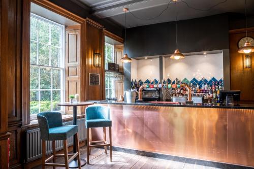 a bar with two blue chairs and a counter at Park House Hotel in Shifnal
