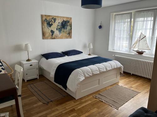 une chambre avec un grand lit et une fenêtre dans l'établissement Maison de vacances à Carantec centre - 4 chambres, à Carantec