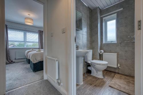 a bathroom with a sink and a toilet and a bed at Spacious 4 BR House w/Parking in Birmingham