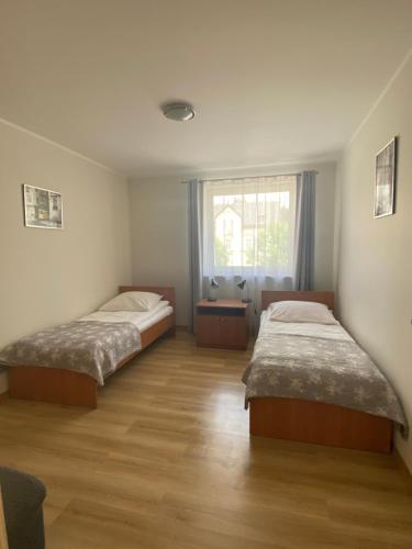 um quarto com duas camas e uma janela em Apartamenty Rodzinne Zdrojowe em Kudowa-Zdrój