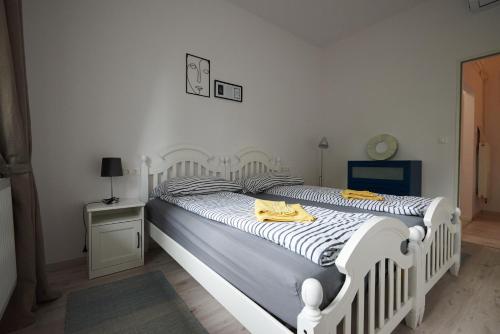 a white bed with yellow towels on it in a bedroom at Piccoleto Bianco in Badacsonytomaj