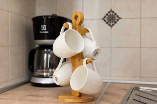 a group of coffee cups on a wooden stand in a kitchen at Apartment Jelusic in Baška