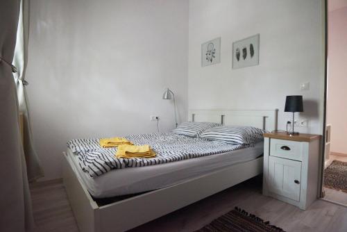 a bedroom with a bed with two yellow towels on it at Piccoleto Bianco in Badacsonytomaj