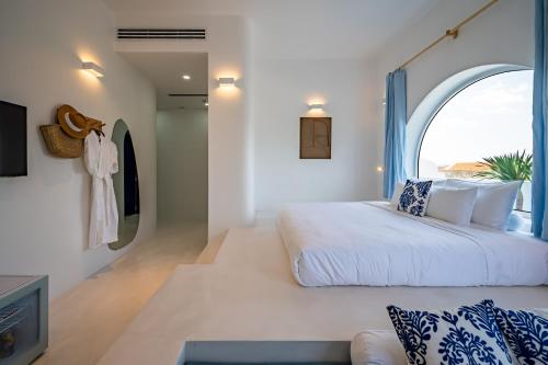 a bedroom with a large bed and an arched window at Happiness Hotel in Quy Nhon