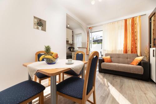 a dining room and living room with a table and chairs at Apartment Jelusic in Baška