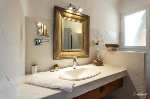 a bathroom with a sink and a mirror at Hôtel Palombaggia, Certifié Ecolabel Européen in Porto-Vecchio