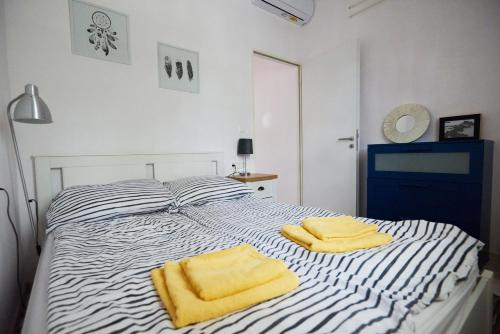a bedroom with a bed with two yellow towels on it at Piccoleto Bianco in Badacsonytomaj