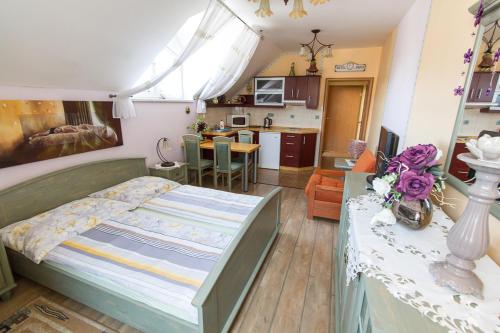 a bedroom with a large bed and a kitchen at Penzion U Kapličky in Malá Hraštice