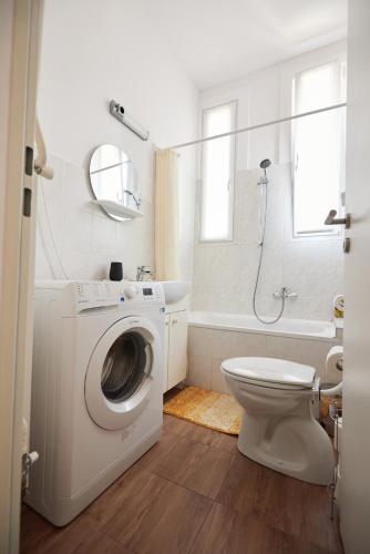 a bathroom with a washing machine and a toilet at Piccoleto Bianco in Badacsonytomaj