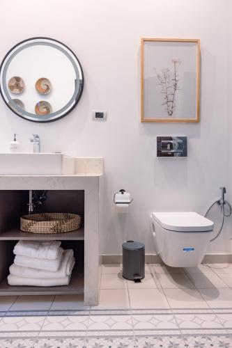 ein Badezimmer mit Waschbecken, Toilette und Spiegel in der Unterkunft Kassa Boutique Hotel in Bethlehem