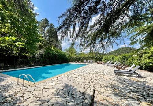 a swimming pool with lounge chairs and trees at Studio Coin nuit 205 Résidence Les Acacias in Anduze