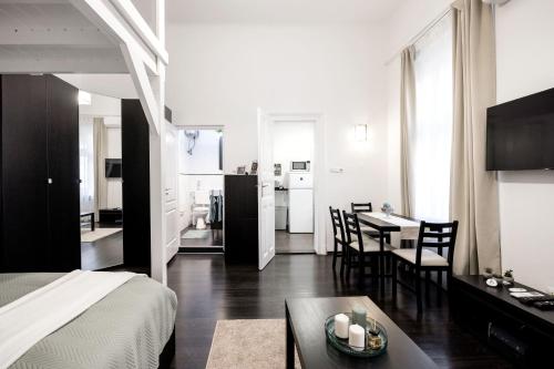 ブダペストにあるCharming Downtown Hideaway Steps from New York Café!のベッド、テーブル、キッチンが備わる客室です。