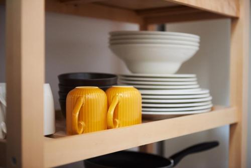 two cups and plates on a shelf with dishes at Piccoleto Bianco in Badacsonytomaj