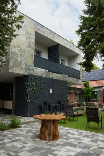 a building with a wooden table in a courtyard at Piccoleto Bianco in Badacsonytomaj