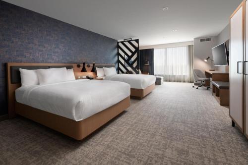 クレイトンにあるResidence Inn by Marriott St Louis Claytonのベッド2台とデスクが備わるホテルルームです。