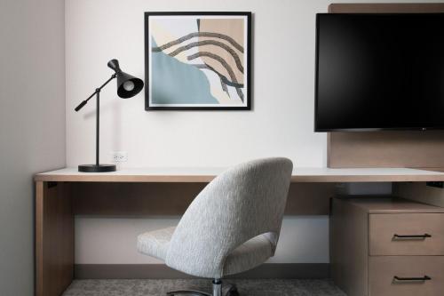 a desk with a chair and a monitor and a lamp at Residence Inn by Marriott St Louis Clayton in Clayton