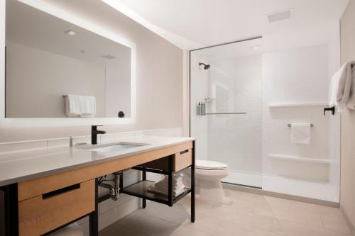 a white bathroom with a sink and a toilet at Residence Inn by Marriott St Louis Clayton in Clayton