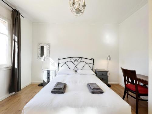 バルセロナにあるCasa Sagrada Familiaのベッドルーム(大きな白いベッド1台、椅子付)