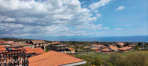 un grupo de casas con techos rojos y el océano en Maremonti, en Zafferana Etnea