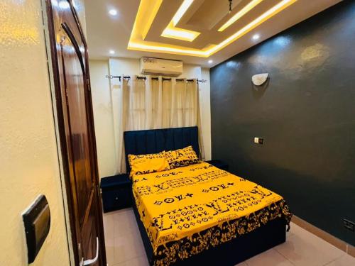 a bedroom with a bed with a yellow blanket at Apartment Diamant in Cotonou