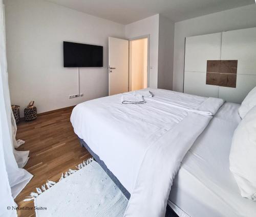 1 dormitorio con 1 cama blanca grande y TV de pantalla plana en Relax Suite, en Mörbisch am See