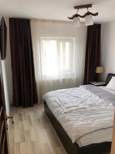 a bedroom with a bed and a window at Page2 Apartament in Târgovişte