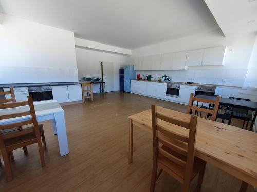 a large kitchen with a table and chairs in a room at Akdeniz Pension in Ludwigsfelde