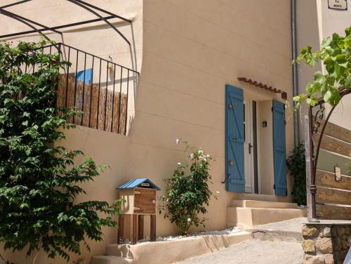 uma casa com uma porta azul e escadas em Petite pause à Pourrières, appartement 40m2 em Pourrières