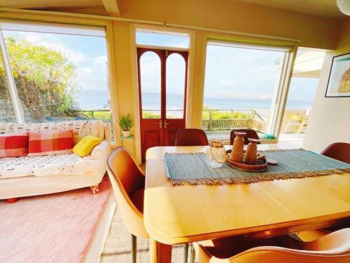 a living room with a table and a couch at Incredible Waterview - 4 Bedroom Hobart Waterside Cottage in Sandy Bay