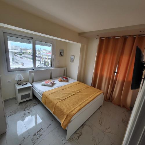 a small bedroom with a bed and a window at Luksuzni Apartman Harmonija Paralija in Paralia Katerinis