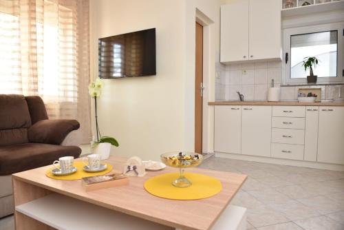 a kitchen and living room with a table and a couch at Apartment Kap in Ivanica