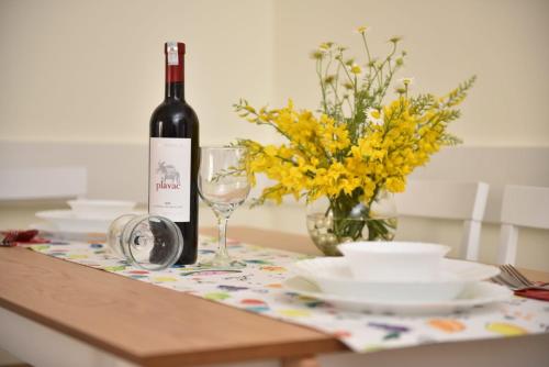 a bottle of wine and a glass on a table at Apartment Kap in Ivanica