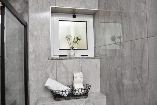 a bathroom with a picture and a basket of towels at Apartment Kap in Ivanica