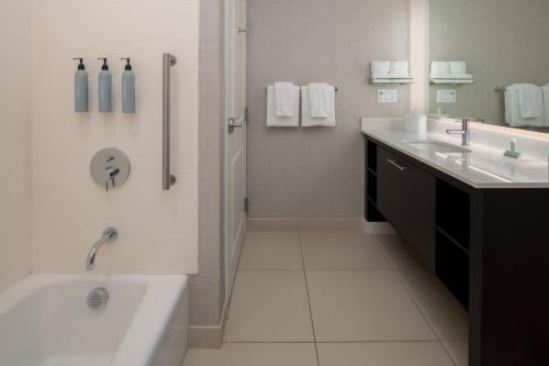 a bathroom with a tub and two sinks and a shower at Residence Inn by Marriott Portland Vancouver in Vancouver