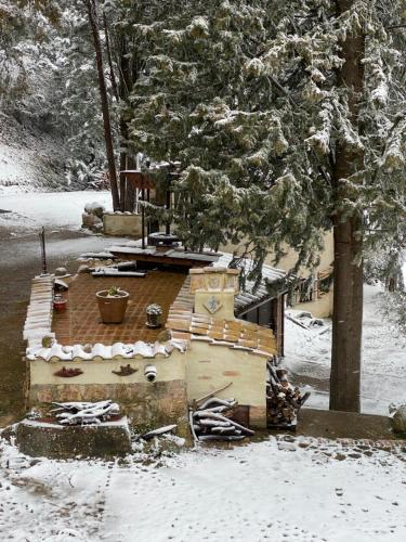 a woodburning stove in the snow under a tree at La Tana del Grifo - Podere Amodeo in Chiusi