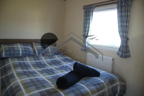 a bedroom with a bed with a blue plaid at The Rivington Lodge in Heysham