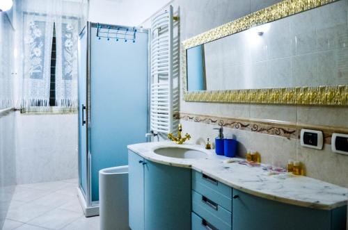 a bathroom with a sink and a mirror and a shower at La casa al faro in Bari