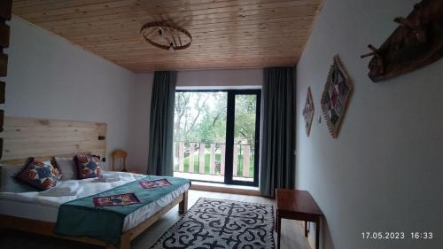 a bedroom with a bed and a large window at Guest House Jekshen in Imeni Karla Marksa