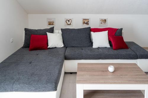 a bedroom with a large bed with red and grey pillows at Holiday House Zrmanja Vrelo in Zrmanja Vrelo