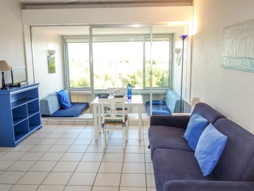 a living room with a couch and a table at Apartment Athéna Résidence by Interhome in Bandol